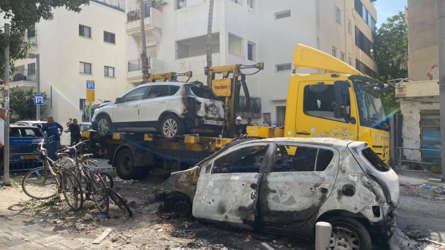 מכוניות שנפגעו מרקטה מפונות מהרחוב בתל אביב