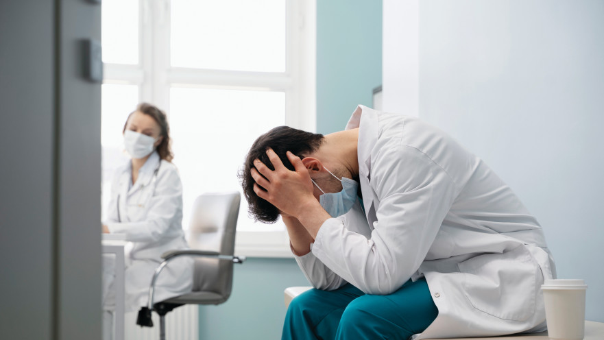 medium-shot-sad-doctor-wearing-mask