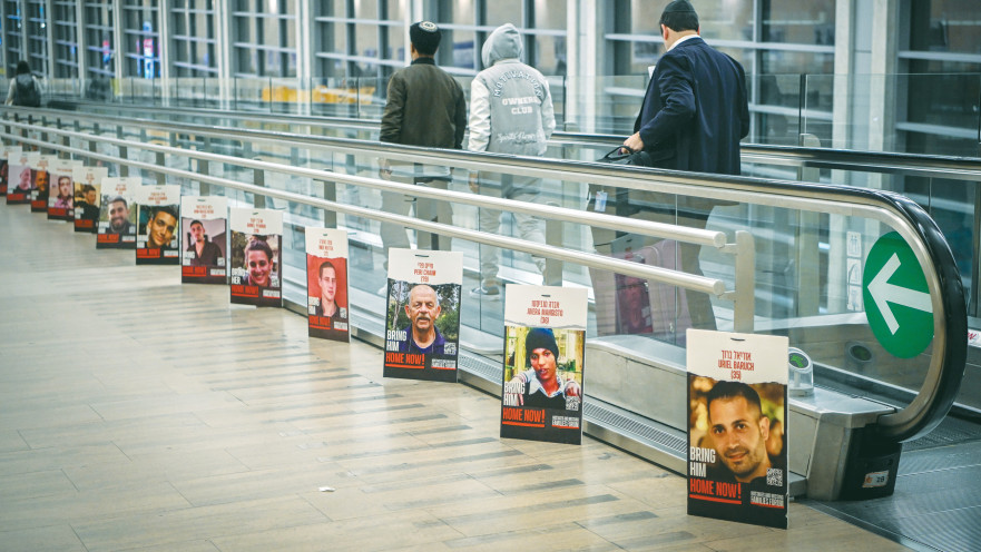 תמונות החטופים לצד המסוע בנתב"ג