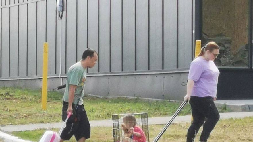 פעוטה נגררת בכלוב על ידי זוג מבוגרים