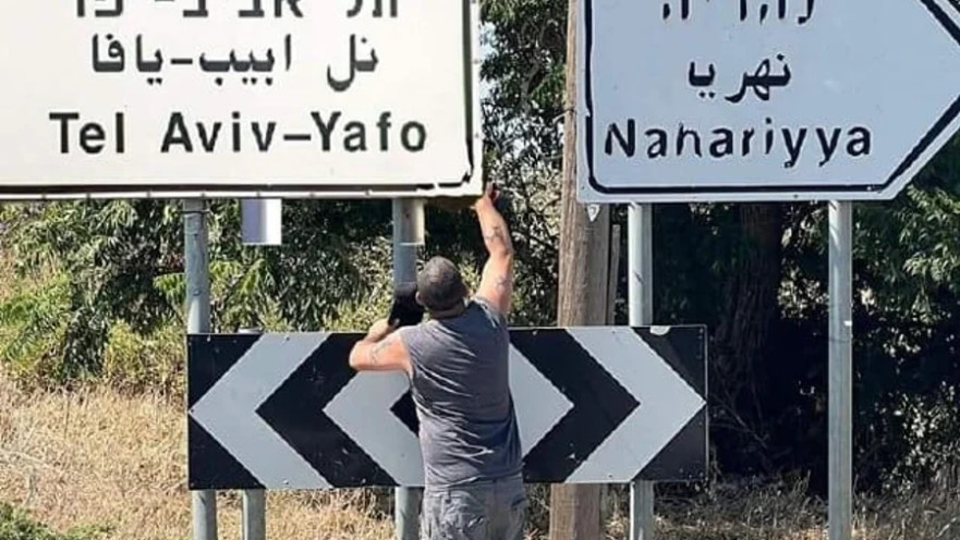 צחי אליהו מחליף את השלט של עין יעקב בשלט של העיר תל אביב