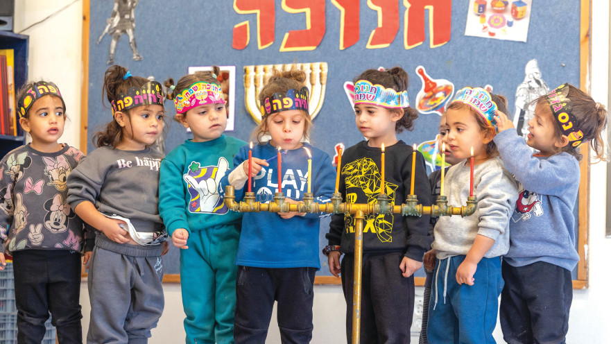 ילדים מדליקים חנוכייה במושב ישרש