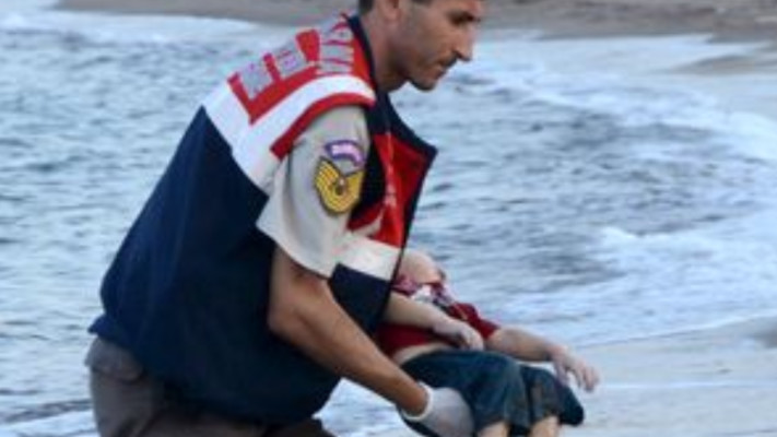 הקצין הטורקי נושא את הפעוט הסורי. צילום מסך: אתר המירור