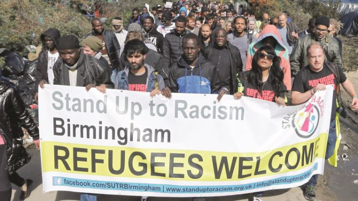 פליטים ונציגי ארגוני סיוע בהפגנה. צילום: רויטרס