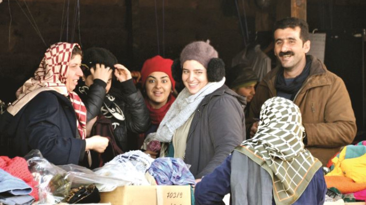 פליטים אפגניים מקבלים ציוד חם לחורף במרכז סיוע בבלגרד. צילום: תמר דרסלר