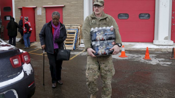 איש המשמר הלאומי שנשלח לחלק מי שתייה בעקבות המשבר. צילום: רויטרס