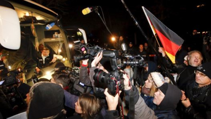 הפגנה נגד מדיניות הדלת הפתוחה של מרקל מול אוטובוס ובו פליטים שהגיעו. צילום: רויטרס