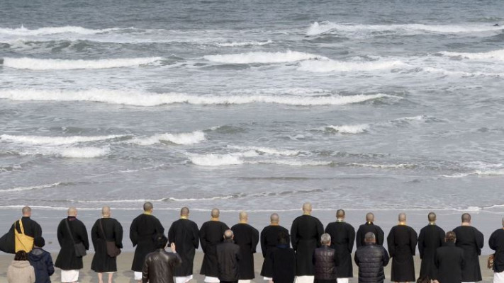 נזירים על החוף בפוקושימה, היום. צילום: רויטרס