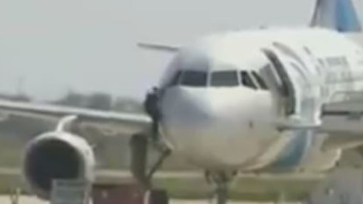 חוטף המטוס המצרי יוצא דרך חלון תא הטייס, צילום מסך מתוך פייסבוק