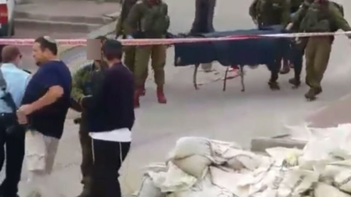 החייל היורה מחברון לוחץ יד עם ברוך מרזל. צילום מסך מתוך סרטון בצלם