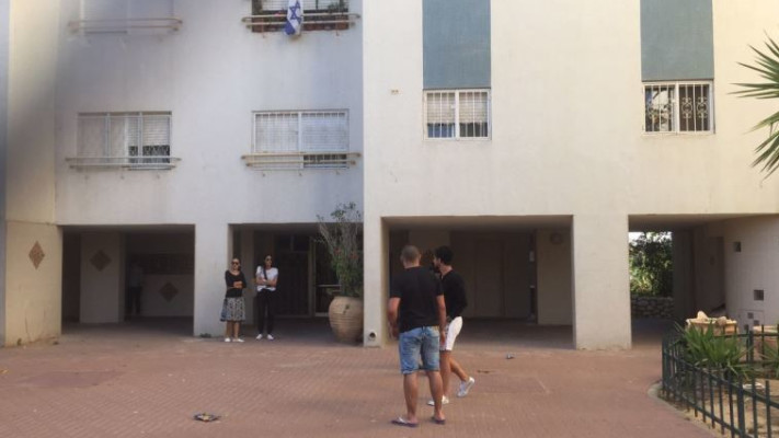השכנים מחוץ לבניין שבו נפל בן הארבע. צילום: יאסר עוקבי