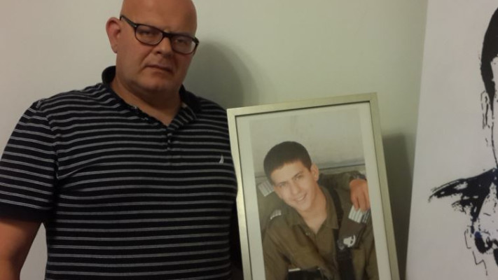נתניהו מנסה להדוף את הביקורת. אילן ארז עם תמונת בנו שגיא ז"ל. צילום: באדיבות המשפחה