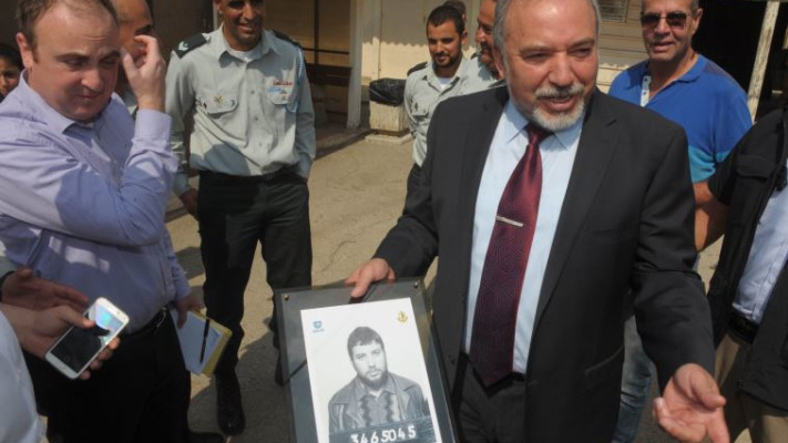 ליברמן עם תמונתו ביום הגיוס, היום. צילום: אבשלום ששוני