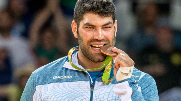 אורי ששון והמדליה. צילום: אסף קליגר