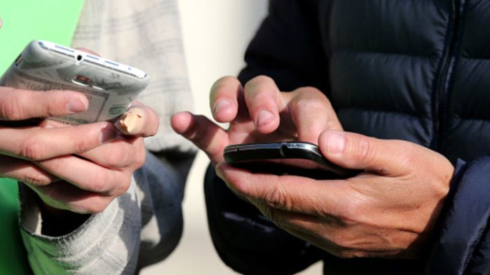 אנשים מחזיקים טלפונים סלולריים