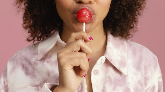 אישה מלקקת סוכריה על מקל (צילום: אינגאימג')