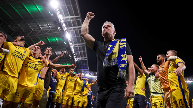 מיטש גולדהאר חוגג עם שחקני מכבי תל אביב מול הקהל הצהוב (צילום: מאור אלקסלסי)