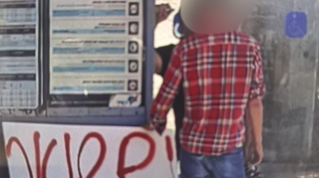 החשוד שנעצר עם השלט שנשא (צילום: דוברות המשטרה,ביטחון הרכבת הקלה)