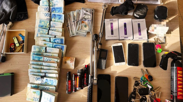 כלי תקיפה, טלפונים וכסף שנמצאו בביתו של החשוד (צילום: דוברות המשטרה)