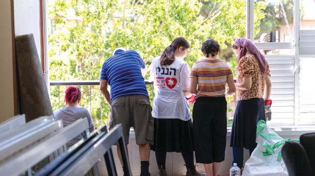 מתנדבים מסדרים דירה שנפגעה מטיל איראני  (צילום: דור פוזאלו)