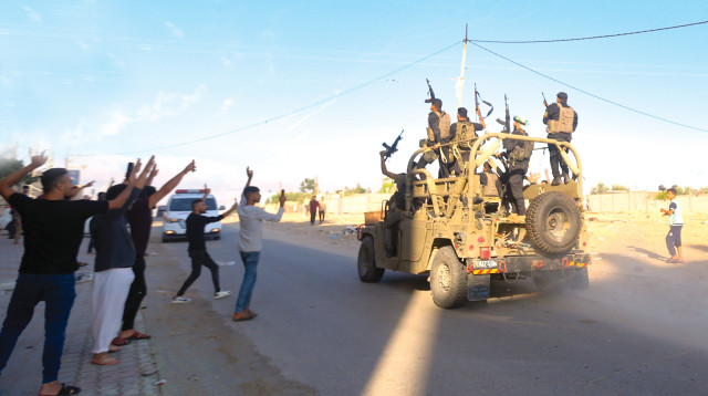 מחבלי חמאס ופלסטינים מהרצועה חוגגים עם ג'יפ של צה"ל (צילום: עטיה מוחמד, פלאש 90)