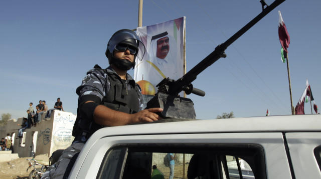 מחבל חמאס על רקע דגל קטאר (צילום:  REUTERS/Ibraheem Abu Mustafa)