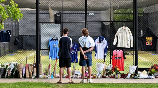 פרחים וציוד קריקט שהונחו לזכרו של בן אוסטין (צילום: WILLIAM WEST)