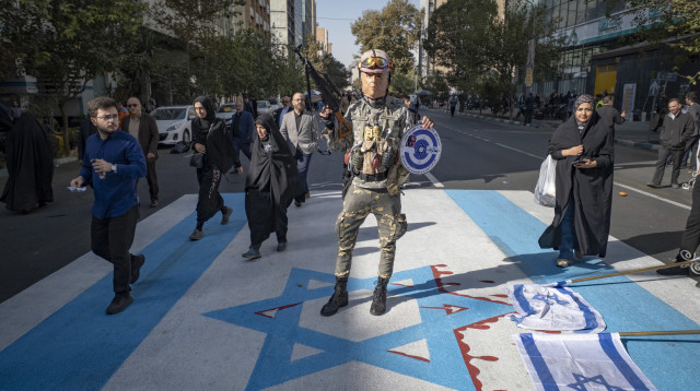חמוש בתחפושת דונלד טראמפ דורך על דגל ישראל בהפגנות באיראן (צילום: רויטרס)