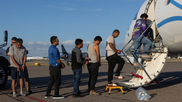 מהגרים מועלים על מטוס  (צילום: רויטרס)