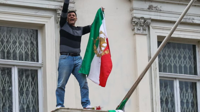 הסרת דגל איראן מבניין השגרירות בלונדון בידי מפגין (צילום: צילום מסך bbc)