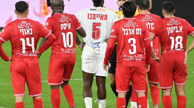 השופט שניר לוי ליד שחקני הפועל חיפה ושחקן הפועל תל אביב, פרנן מאיימבו (צילום: ברני ארדוב)