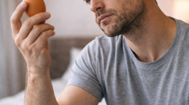 גבר אוחז בביצה (צילום: AI)