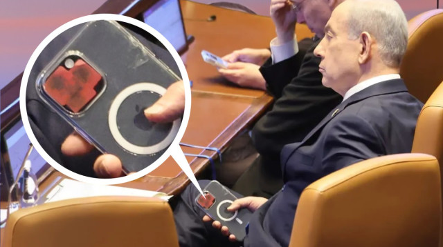 בנימין נתניהו והטלפון הנייד שמצלמתו מכוסה במדבקה (צילום: מארק ישראל סלם)