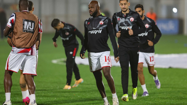 ג'בון איסט שחקן הפועל באר שבע בחימום, מאחוריו מוחמד אבו רומי (צילום: לירון מולדובן)