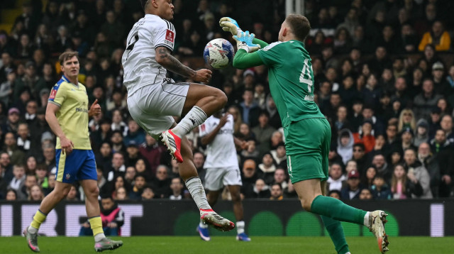 שוער סאות'המפטון דניאל פרץ מול חלוץ פולהאם רודריגו מוניז (צילום: GettyImages, Glyn KIRK / AFP)