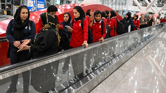 שחקניות נבחרת איראן בשדה התעופה באוסטרליה (צילום: GettyImages, Mohd RASFAN / AFP)