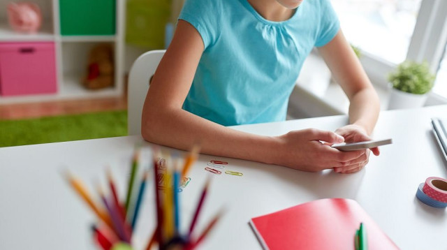 ילדה צופה בחדשות בטלפון (צילום: אינג'אימג')