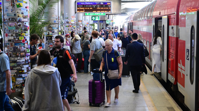 נוסעים בתחנת הרכבת בנתב"ג (צילום: אבשלום ששוני)