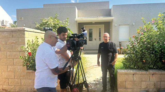 שמעון אלקבץ על רקע ביתו בכפר עזה (צילום: פרטי)