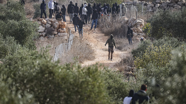 מתנחלים רעולי פנים תוקפים פלסטינים בעת מסיק הזיתים (צילום: פלאש 90)