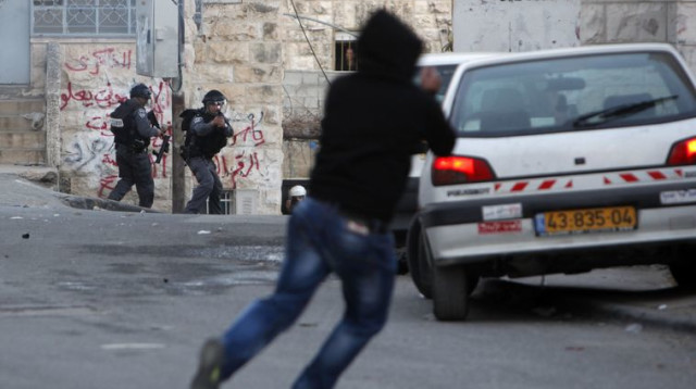 יידוי אבנים על שוטרי מג"ב בידי צעיר פלסטיני (צילום: פלאש 90)