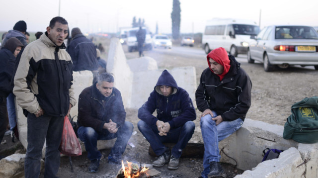 פועלים פלסטינים מחכים להסעות במחסום אייל (צילום: תומר ניוברג, פלאש 90)