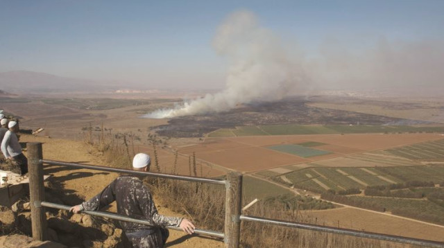 דרוזים צופים בלחימה בסוריה (צילום: רויטרס)