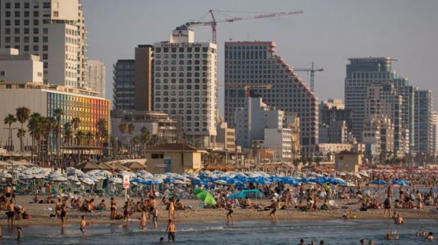 תיירים וישראלים על חוף הים של תל אביב  (צילום: מרים אלסטר, פלאש 90)