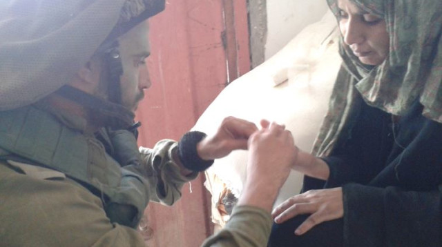 קצין אוכלוסיה במפגש עם תושבת עזה באזור לחימה במהלך צוק איתן (צילום: דוברות מתפ"ש)