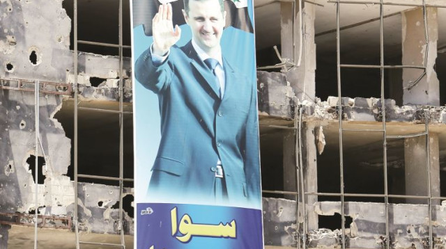 כרזה של אסד על הריסות בניין בחומס (צילום: AFP)