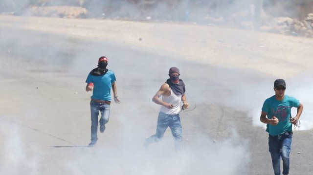 פלסטינים בורחים אחרי שצה"ל ירה גז מדמיע לעברם (צילום: רויטרס)