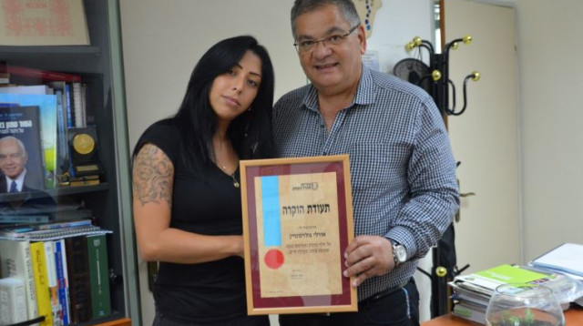 אורלי גולדשטיין מקבלת תעודת הוקרה מאלי ברדה (צילום: דוברות עיריית מגדל העמק)