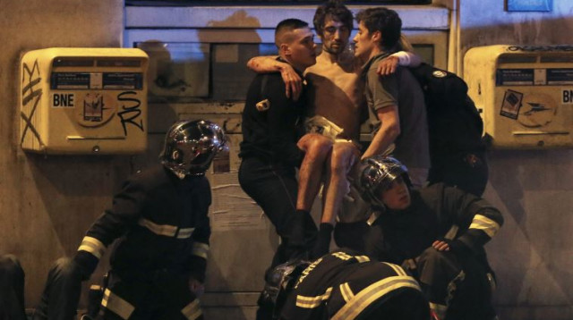 כבאים מחלצים פצועים מאולם בטקלן בפריז  (צילום: רויטרס)