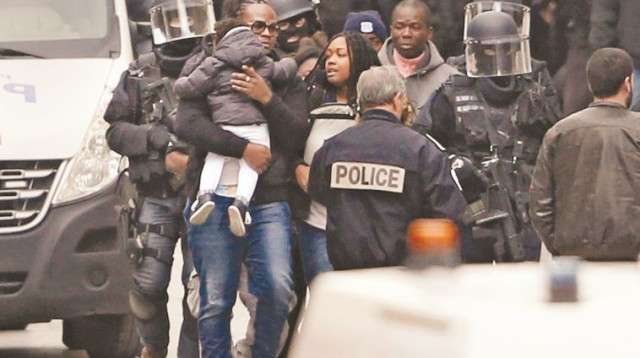 שוטרים צרפתים מחלצים דיירים מהבניין בסאן דני שבו הסתתרו המחבלים (צילום: רויטרס)